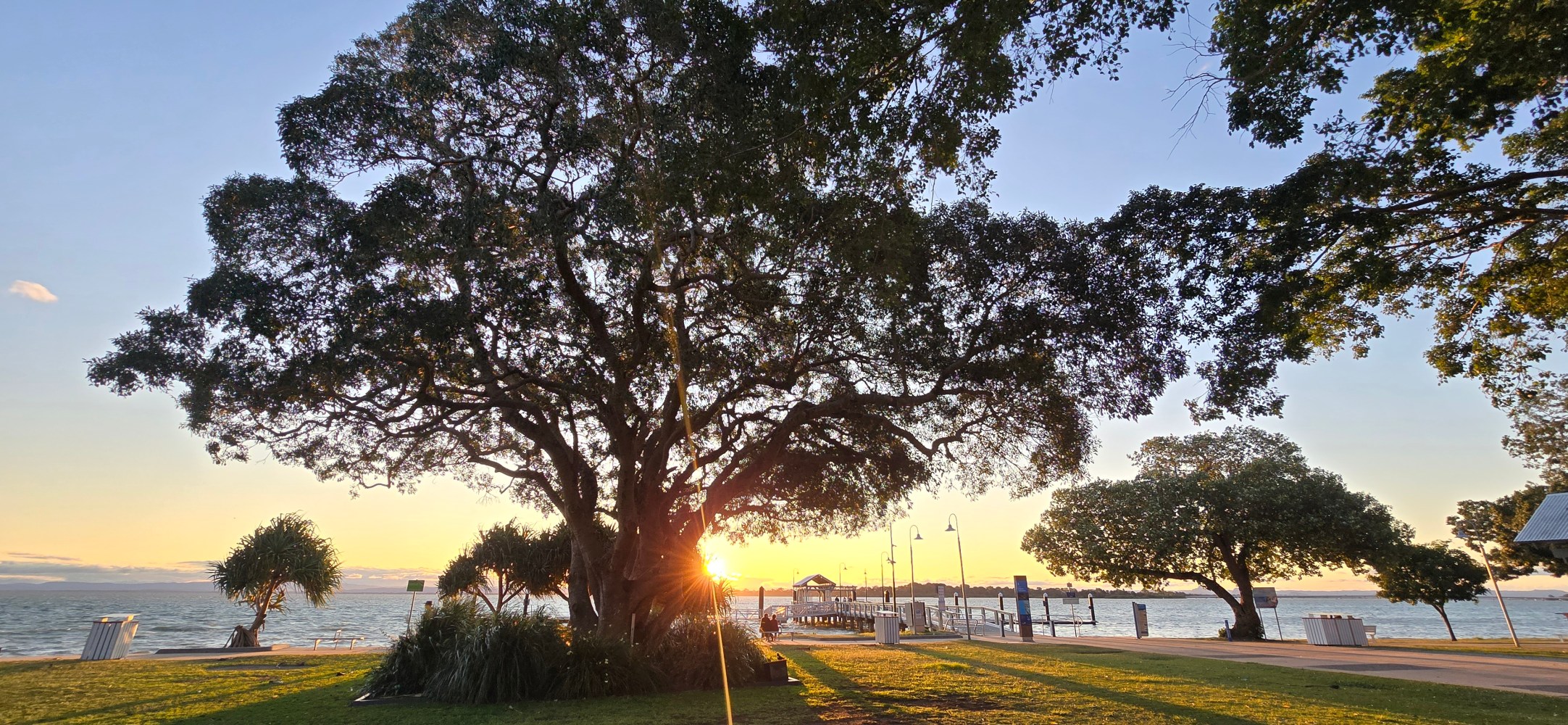 Bongaree Jetty at sunset on Bribie Island, a popular spot for Brisbane day trips and local activities.